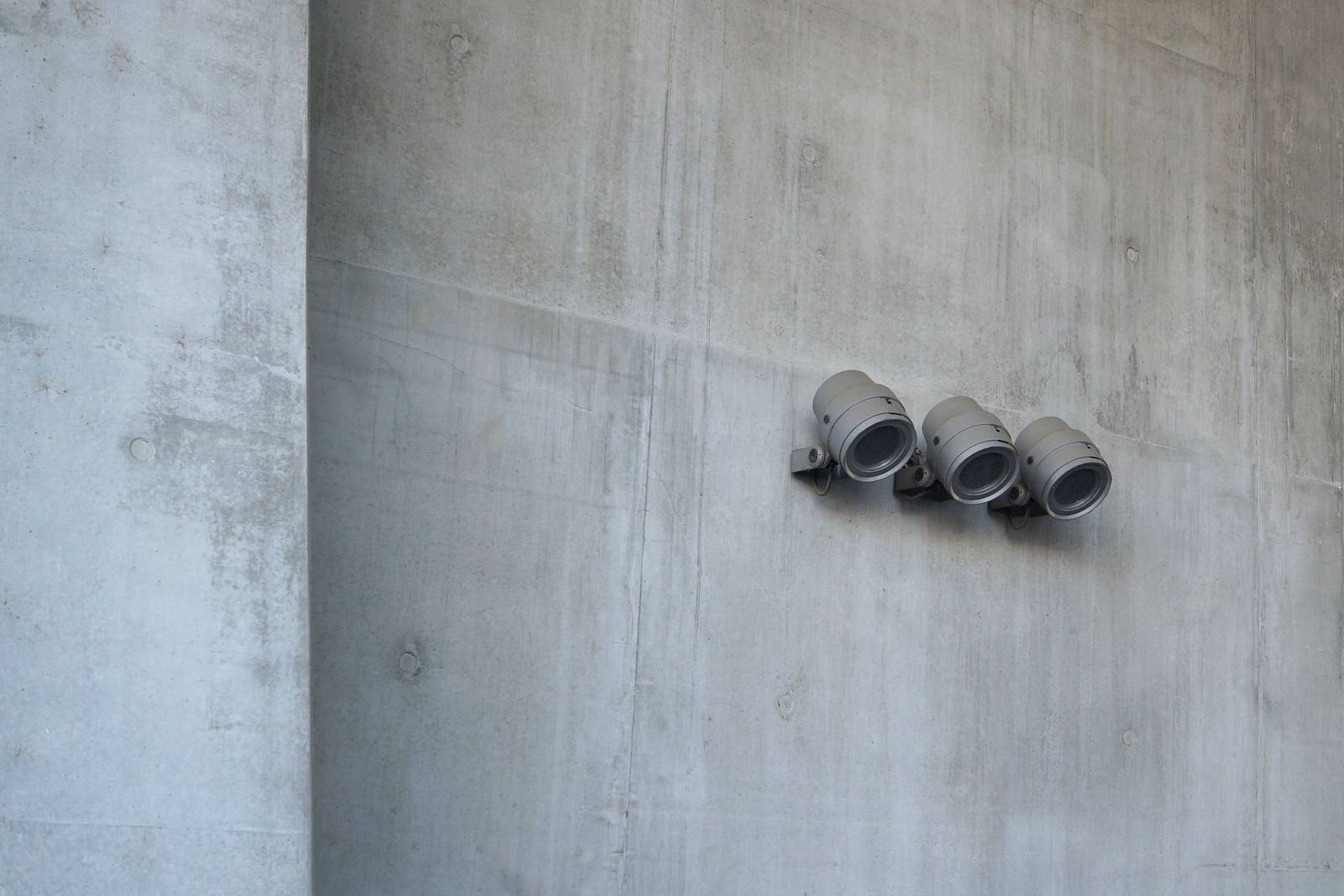 Three small track spots mounted low on a wide concrete wall